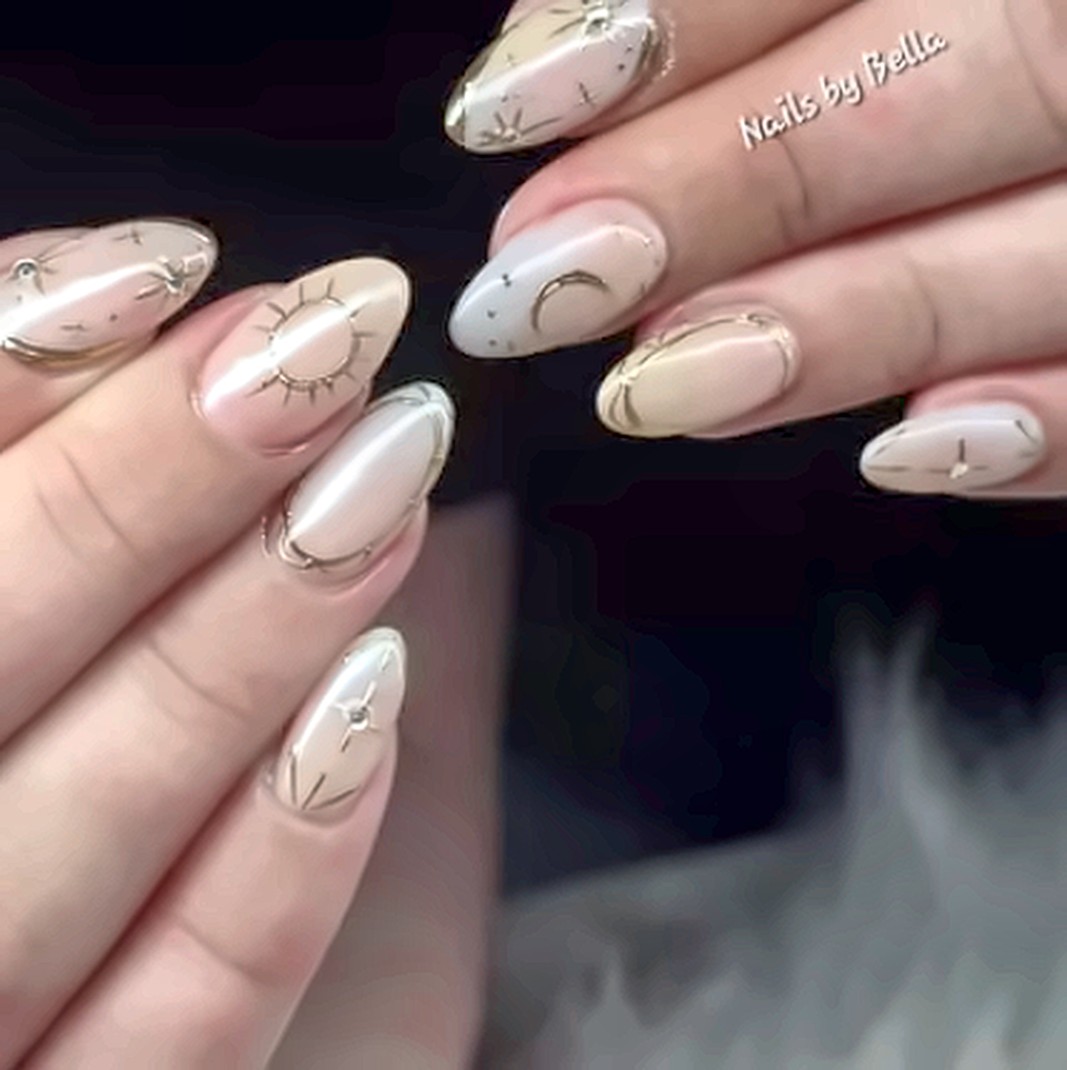 Almond nails in a soft nude with fine gold celestial linework