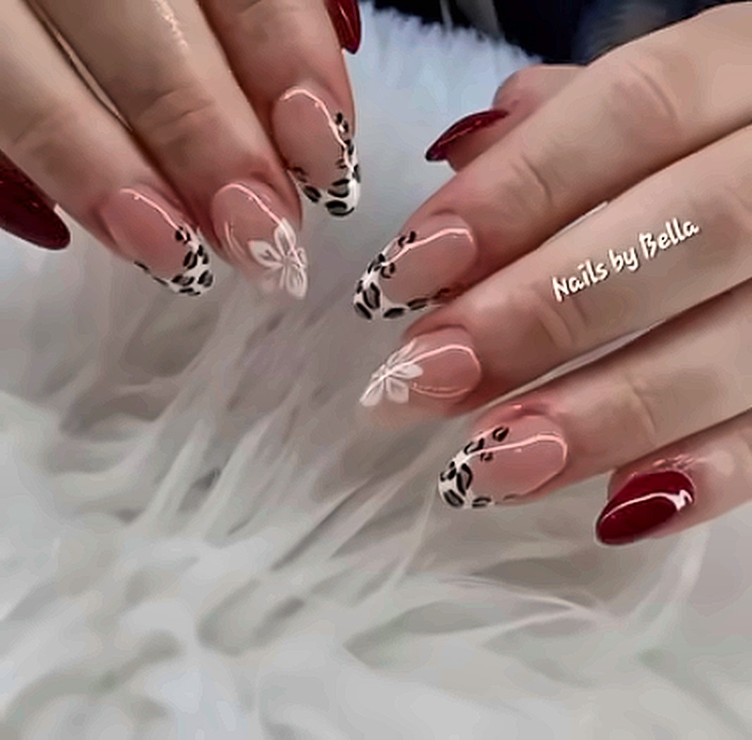 Nude nails with leopard print French tips and burgundy accents