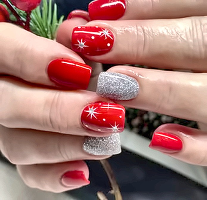 Red nails with white stars and silver glitter accents
